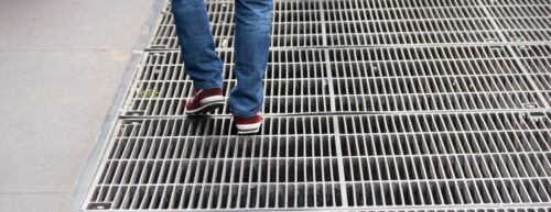 How does sidewalk grating improve drainage in urban walkways?